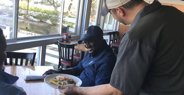 a chef serving food to a customer.